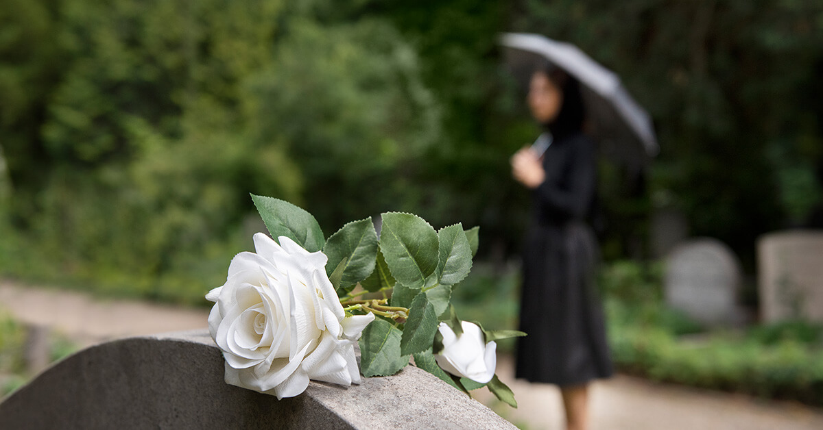 woman in black staning at a grave