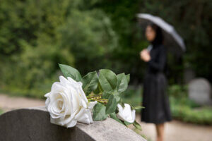 woman in black staning at a grave